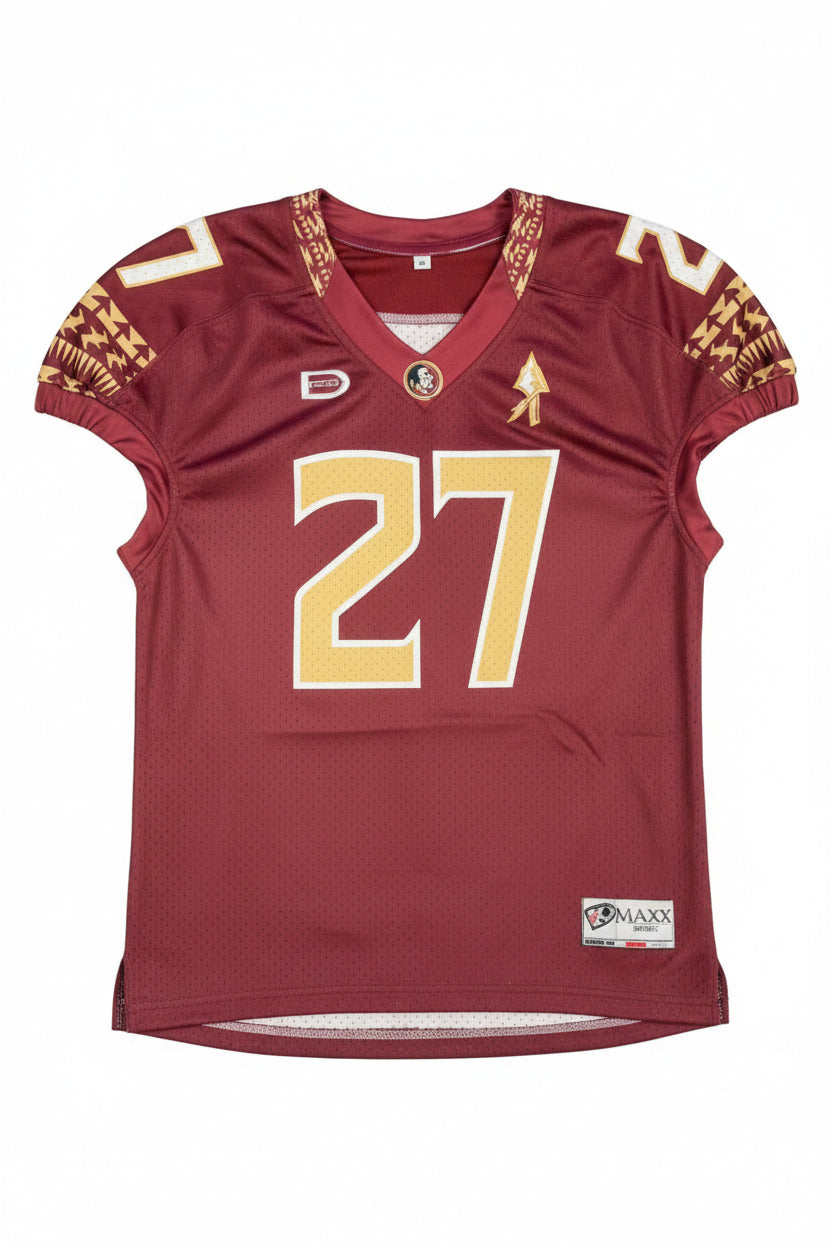 Maroon sports jersey with gold lettering on a gray surface