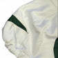 Close-up of a white garment with green trim on a textured surface