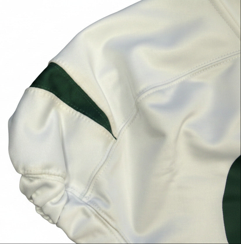 Close-up of a white garment with green trim on a textured surface